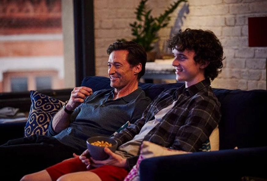 Peter and Nicholas eating popcorn on the couch, a key father-son moment highlighted in The Son movie review.