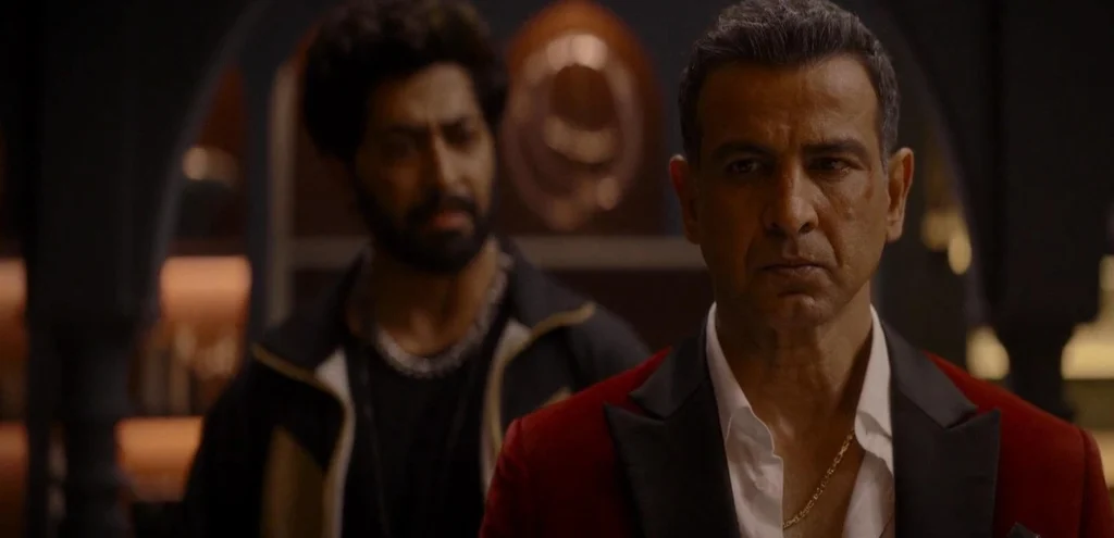Ronit Roy wearing a red jacket and looking unhappy in his hotel room, as featured in this Bloody Daddy movie review.