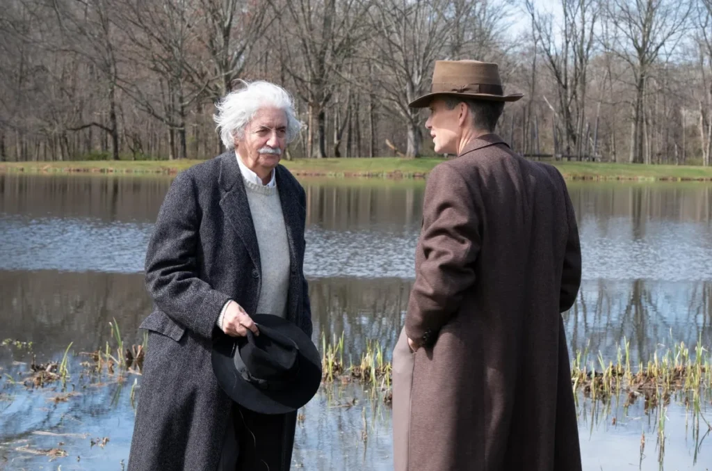 Oppenheimer and Einstein Talking Robert Oppenheimer having a serious talk with Albert Einstein near a lake.